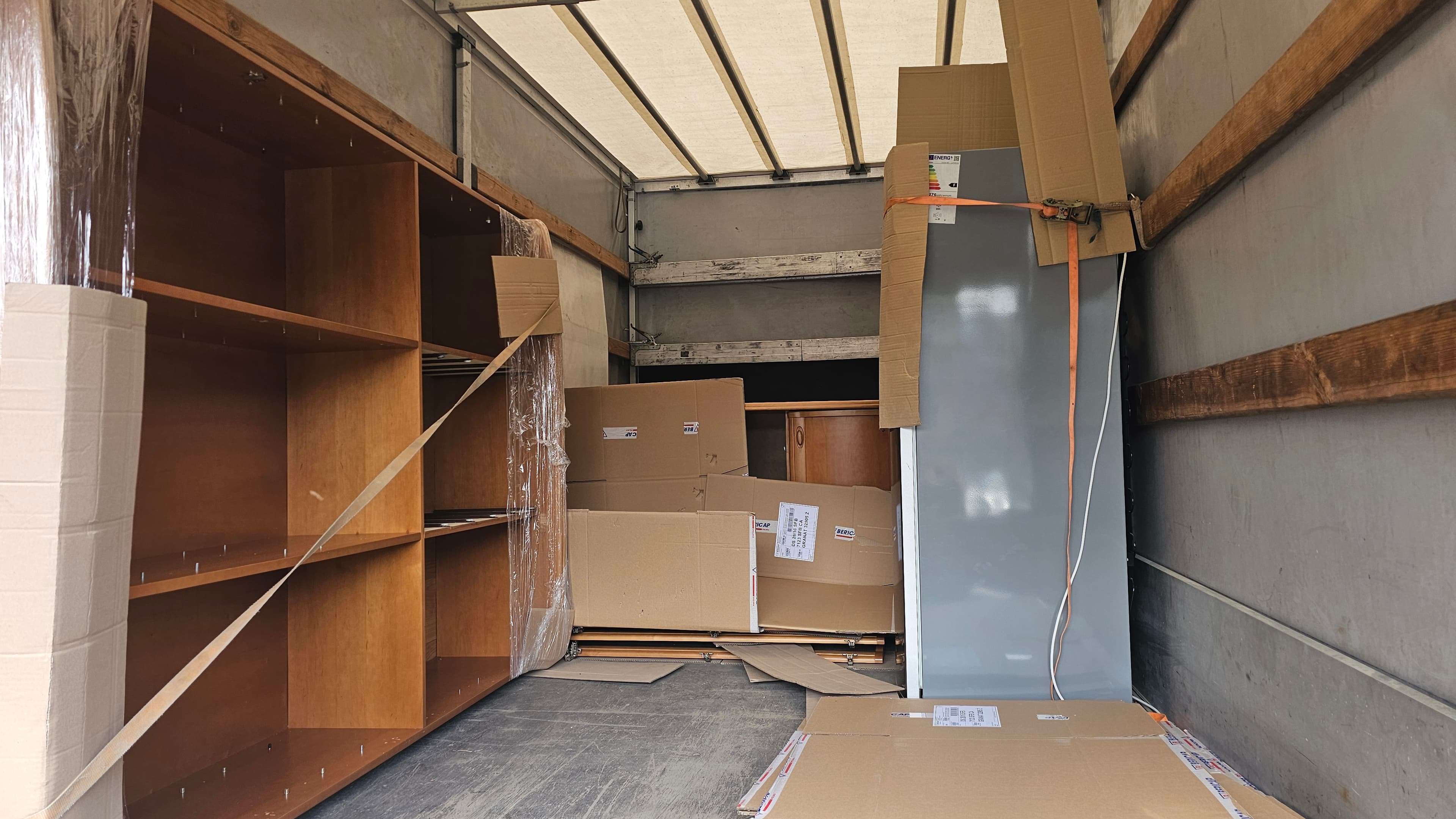 Wnętrze auta transportowego z zabezpieczonymi meblami i kartonami